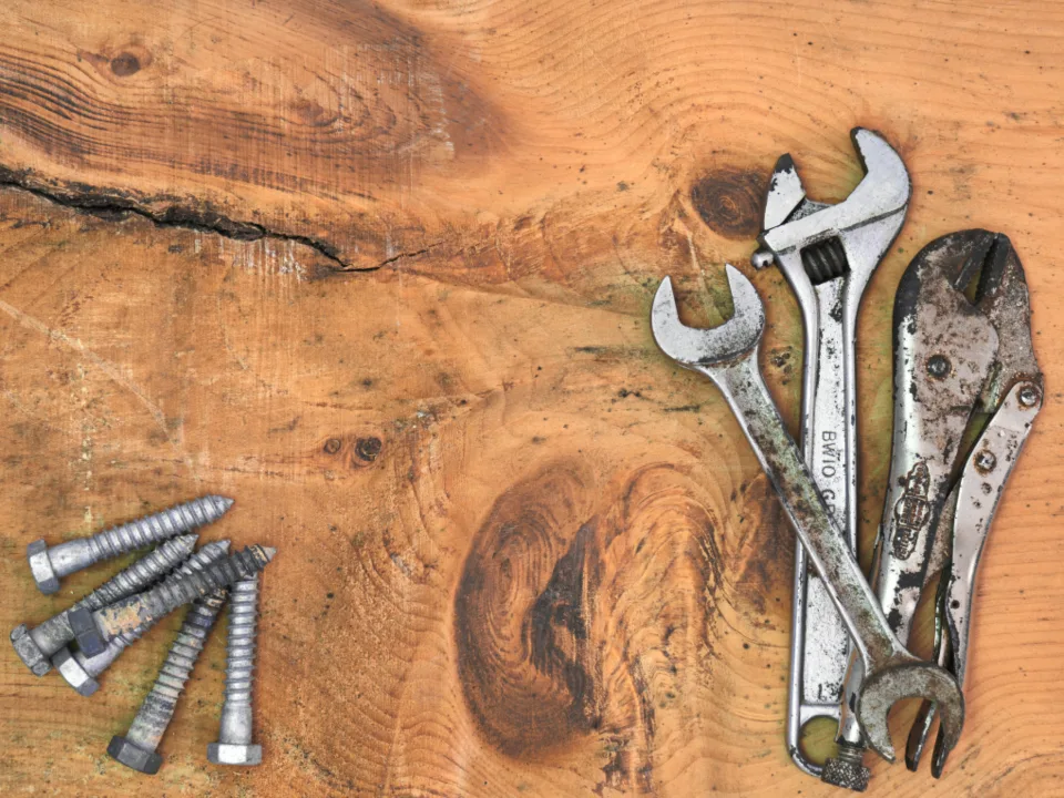 Wrenches and fixings laid out on a wooden workbench